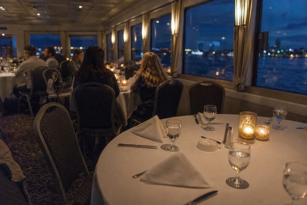 Candlelit dinner tables set on a river cruise boat, no text, no logos, no people