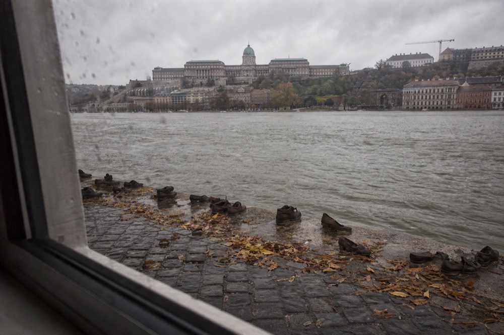 Shoes on the Danube Bank memorial seen from a passing river cruise, no text, no logos, no people