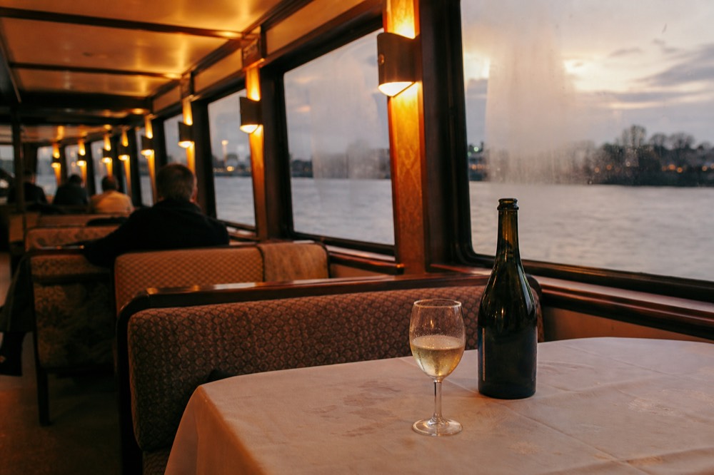 Indoor lounge of a river cruise boat with warm lighting and panoramic windows, no text, no logos, no people