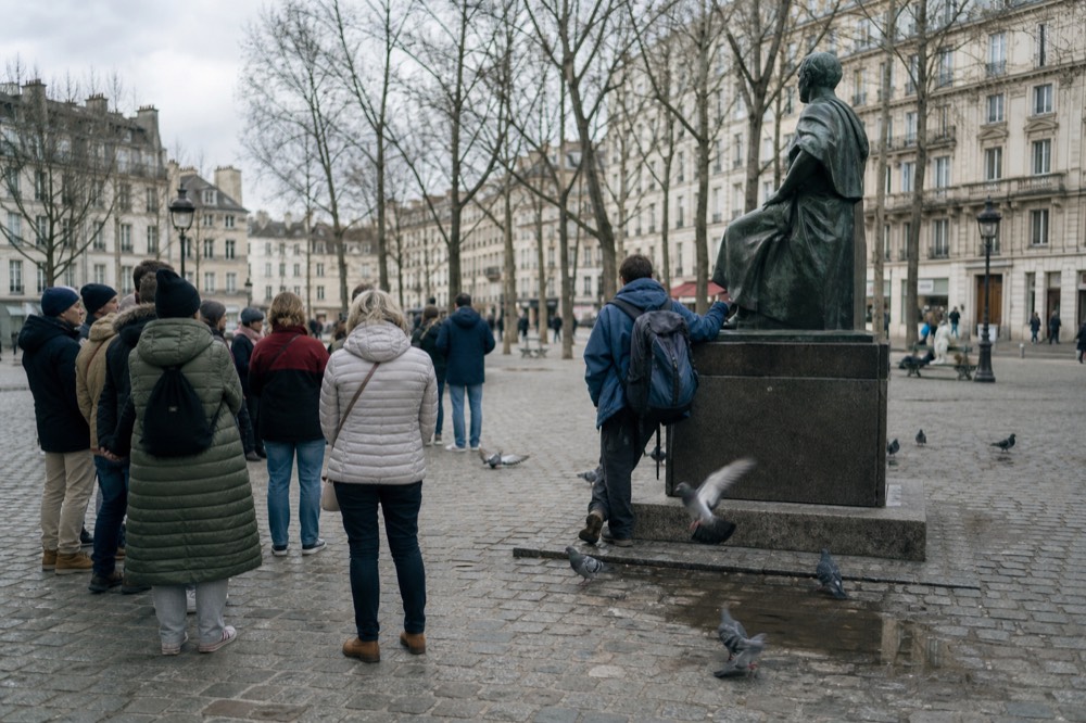 A guided walking group gathered on a Budapest square near a statue, no text, no logos, no people