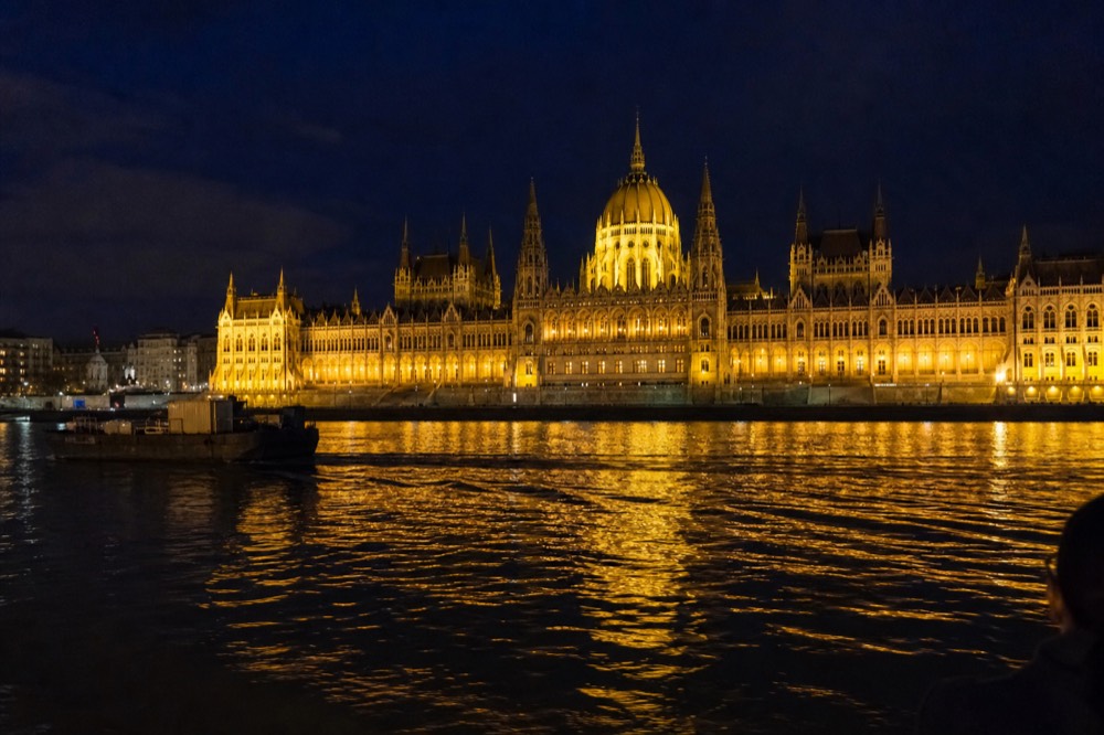The Hungarian Parliament Building seen from the Danube at night with its full facade illuminated, no text, no logos, no people