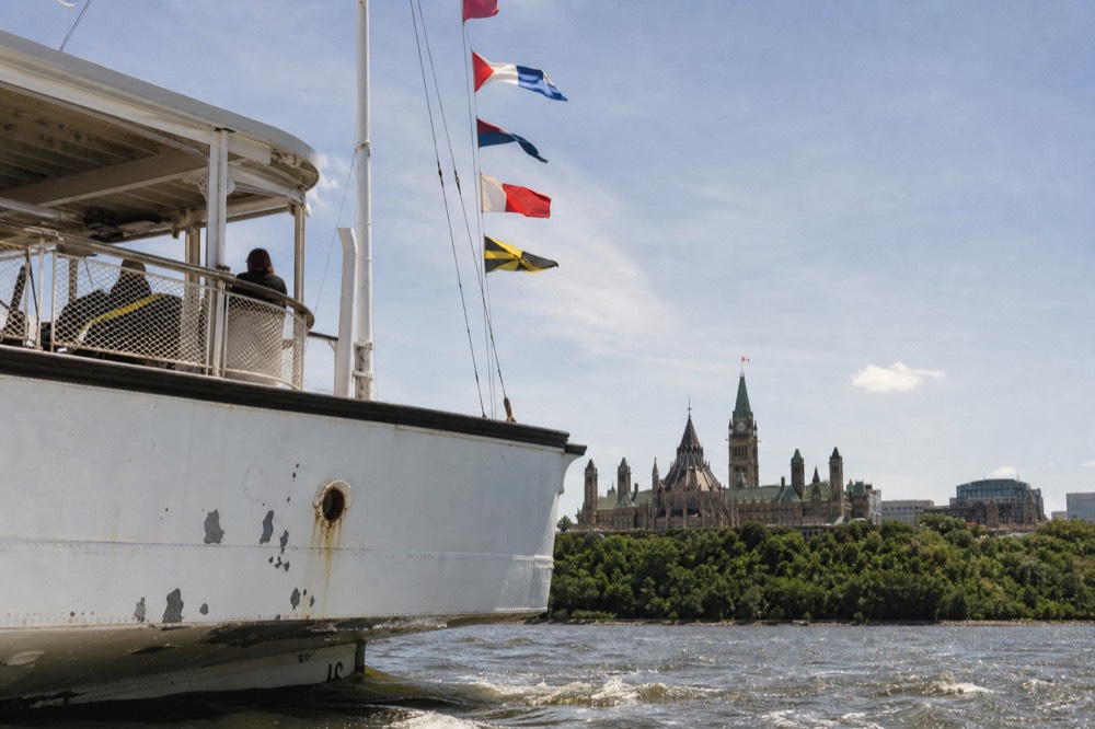 Historic white sightseeing ship on the Danube passing the Hungarian Parliament Building, no text, no logos, no people