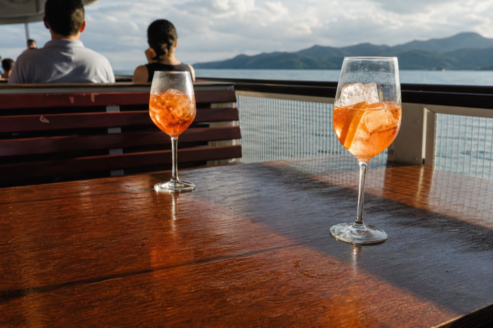 Glasses of prosecco spritz on the open deck of a Budapest river cruise, no text, no logos, no people