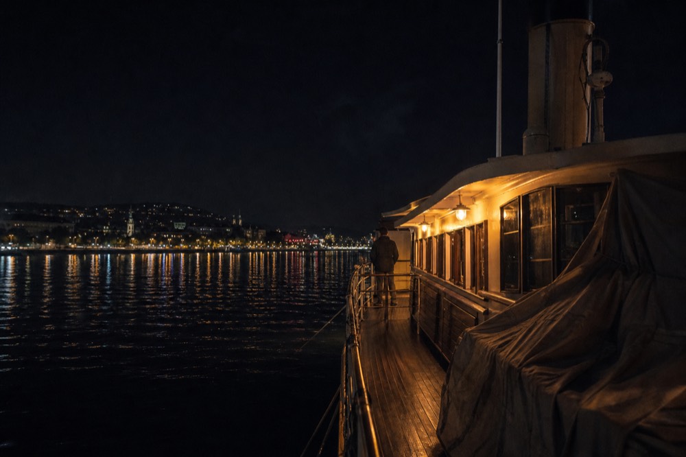 A historic river ship lit at night on the Danube in Budapest, no text, no logos, no people.