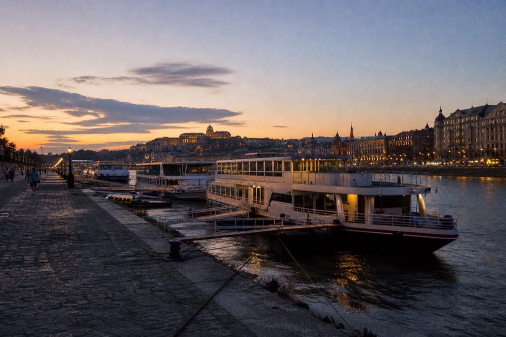 Danube embankment in Budapest with moored sightseeing boats at dusk, no text, no logos, no people