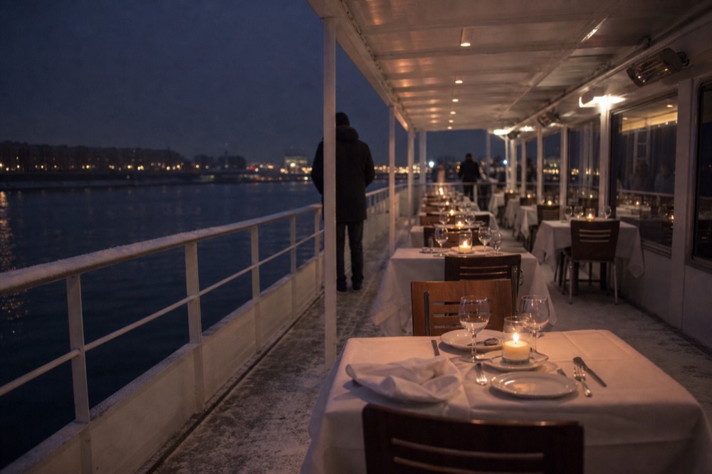 Candlelit dinner tables set aboard a river cruise boat on the Danube, no text, no logos, no people