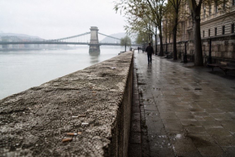The Danube embankment promenade in Budapest with a historic bridge in the distance, no text, no logos, no people