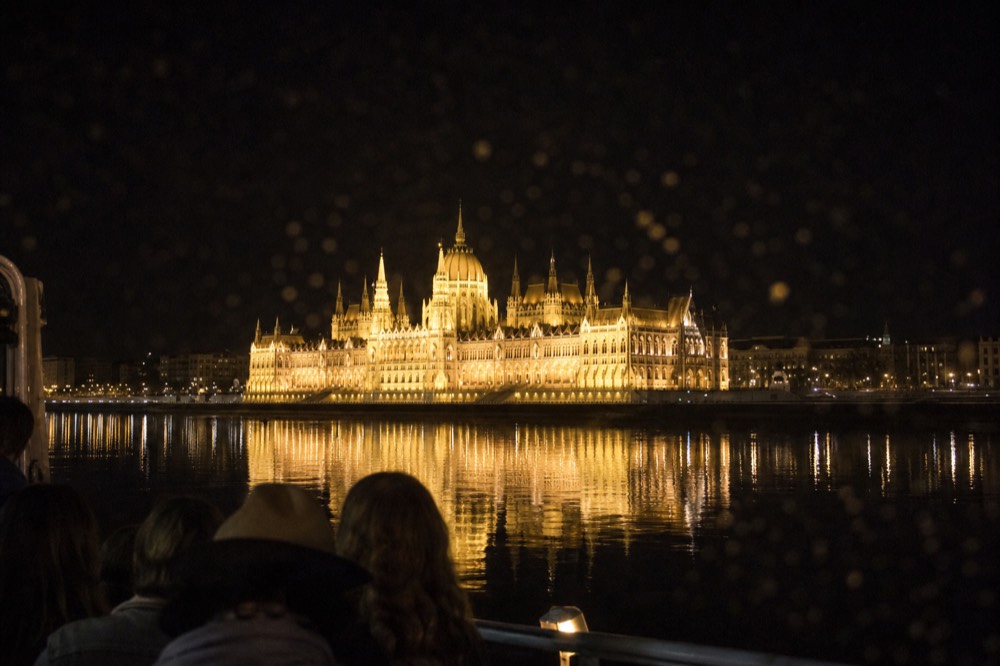 Hungarian Parliament Building illuminated at night viewed from a Danube cruise boat, no text, no logos, no people